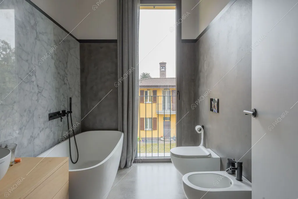 Bagno con vasca e parete in marmo dell'appartamento Fiore di porro, location in stile minimal a Monza