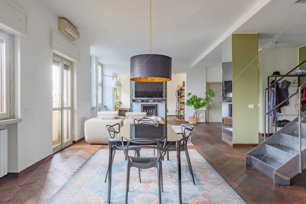 Pavimento in parquet a spina di pesce nella zona living con colonna verde