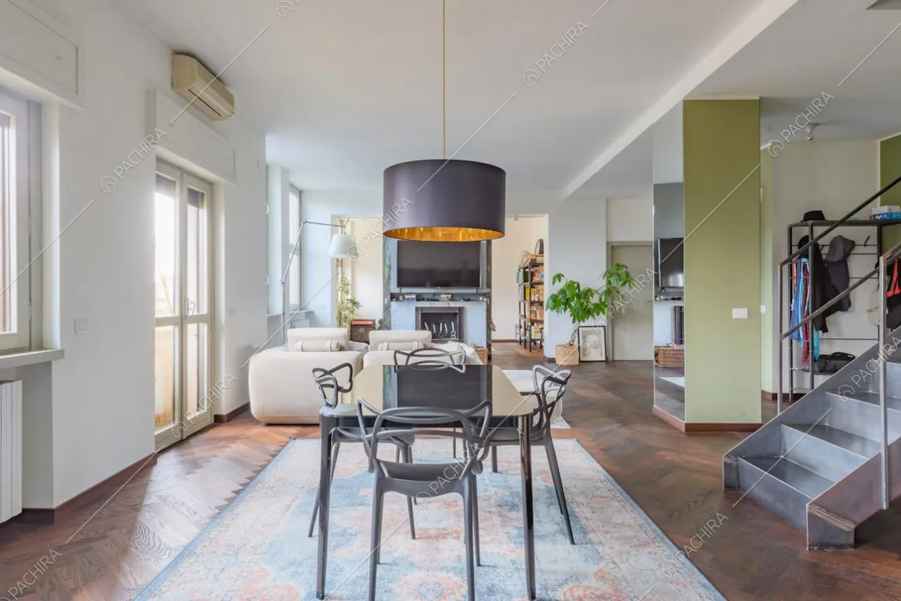Pavimento in parquet a spina di pesce nella zona living con colonna verde