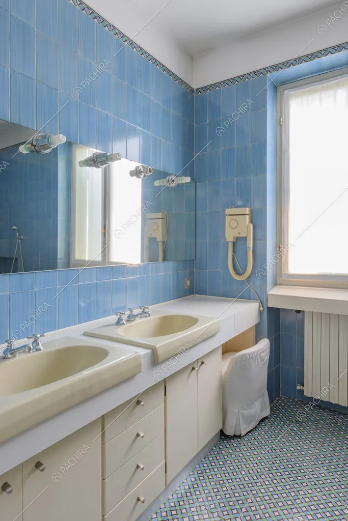 Bagno con doppio lavandino e pareti e pavimento blu