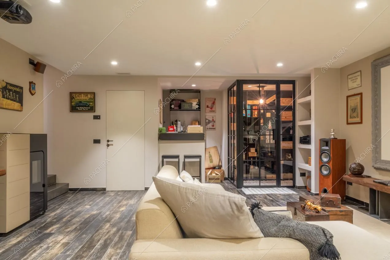Divano bianco nella sala hobby con pavimento in parquet e cantina