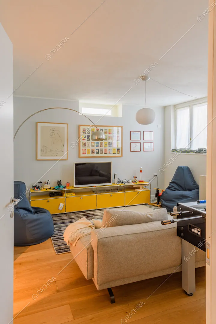 Luminoso salotto con lampada di design e pavimento in parquet