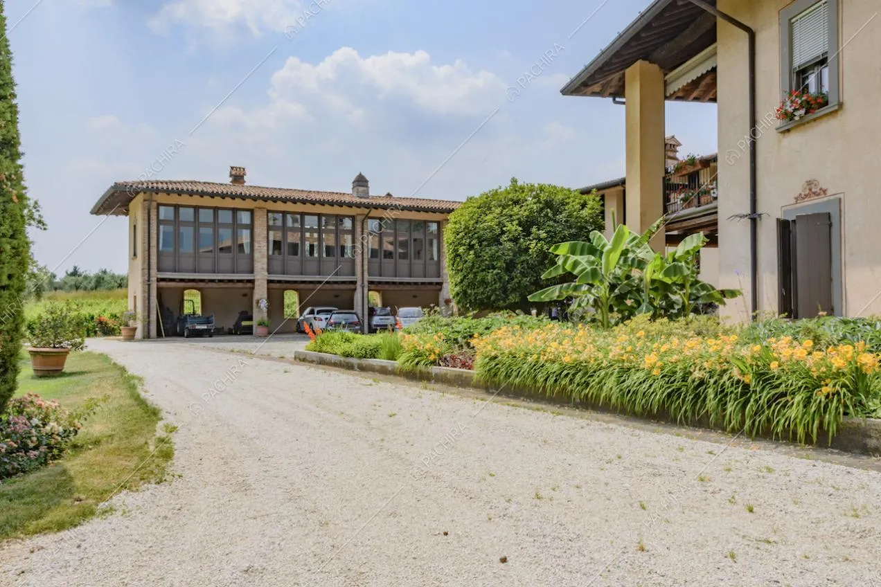 Viale d'accesso alla villa e corte con fiori e piante