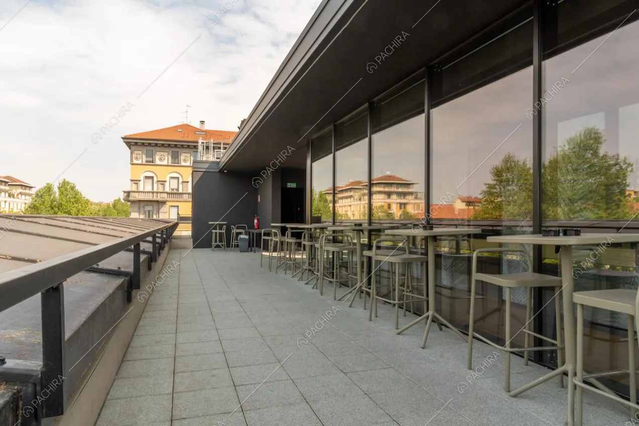 Terrazza con pavimentazione in piastrelle da esterno e tavolini e sgabelli