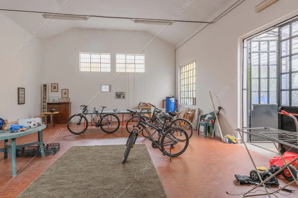 Ampio garage con pareti bianche e finestre in stile industriale