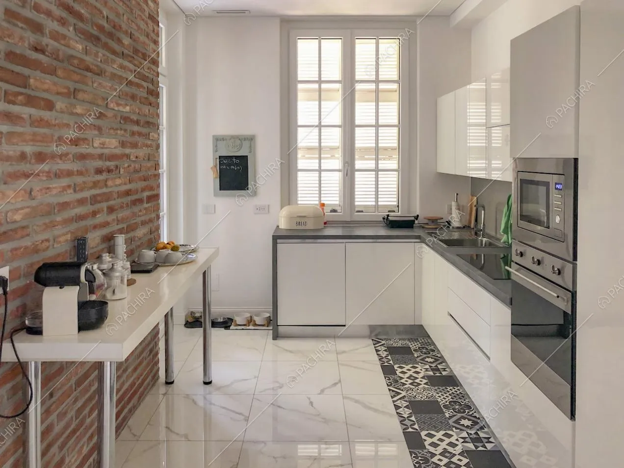 Moderna cucina a parete bianca e parete in mattoni a vista