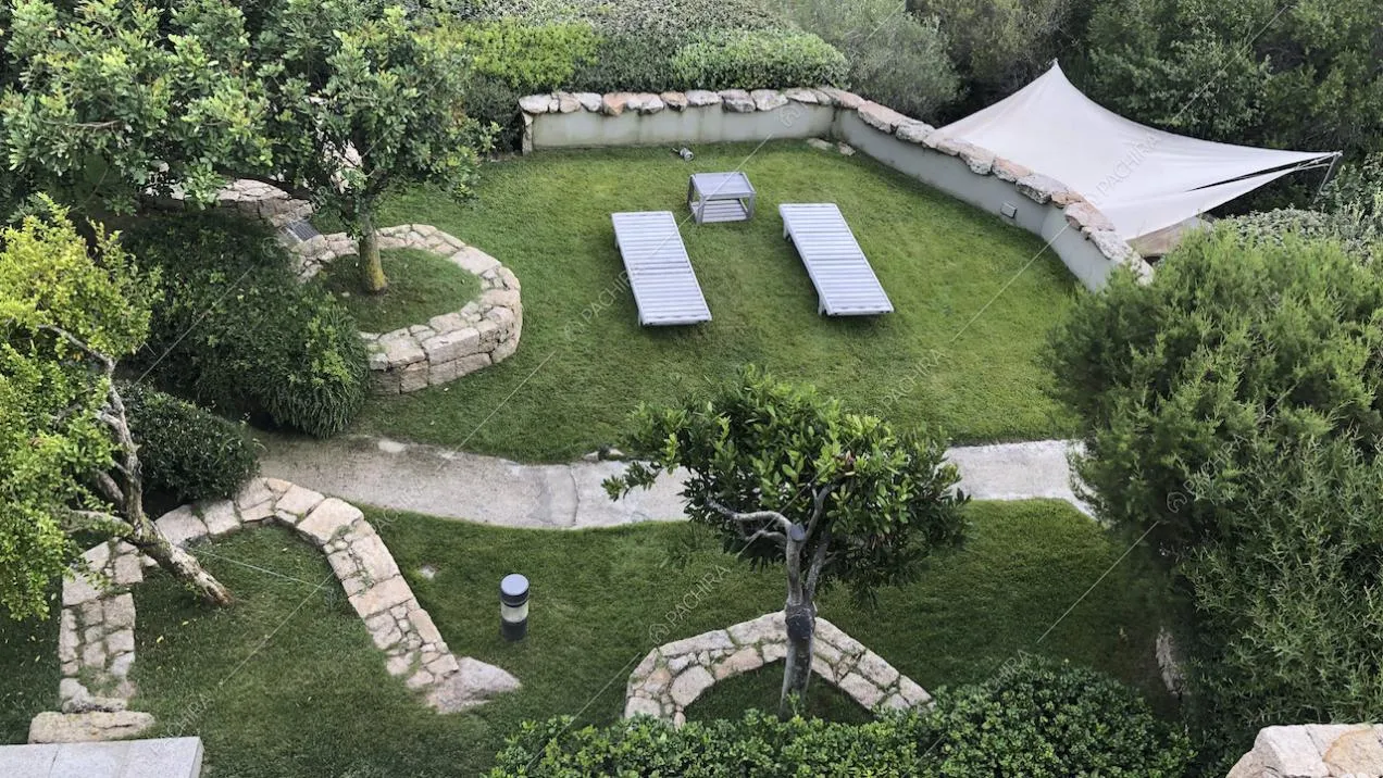 Giardino con alberi, siepi e aiuole in pietra