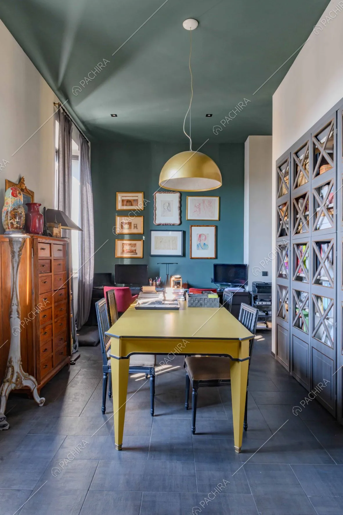 Tavolo giallo dello studio dal pavimento in gres, soffitto e parete blu petrolio
