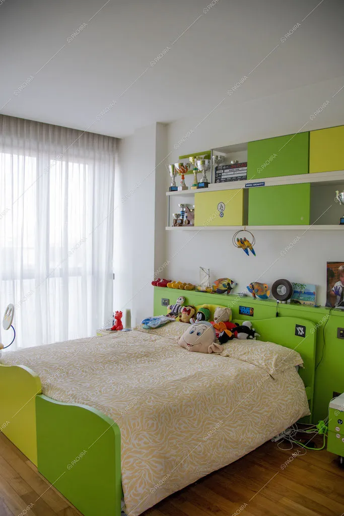 Camera da bambini con letto matrimoniale e pavimento in parquet si distingue per l'arredamento su toni verdi