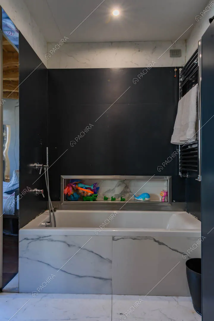 Bagno con pareti nere e vasca in marmo