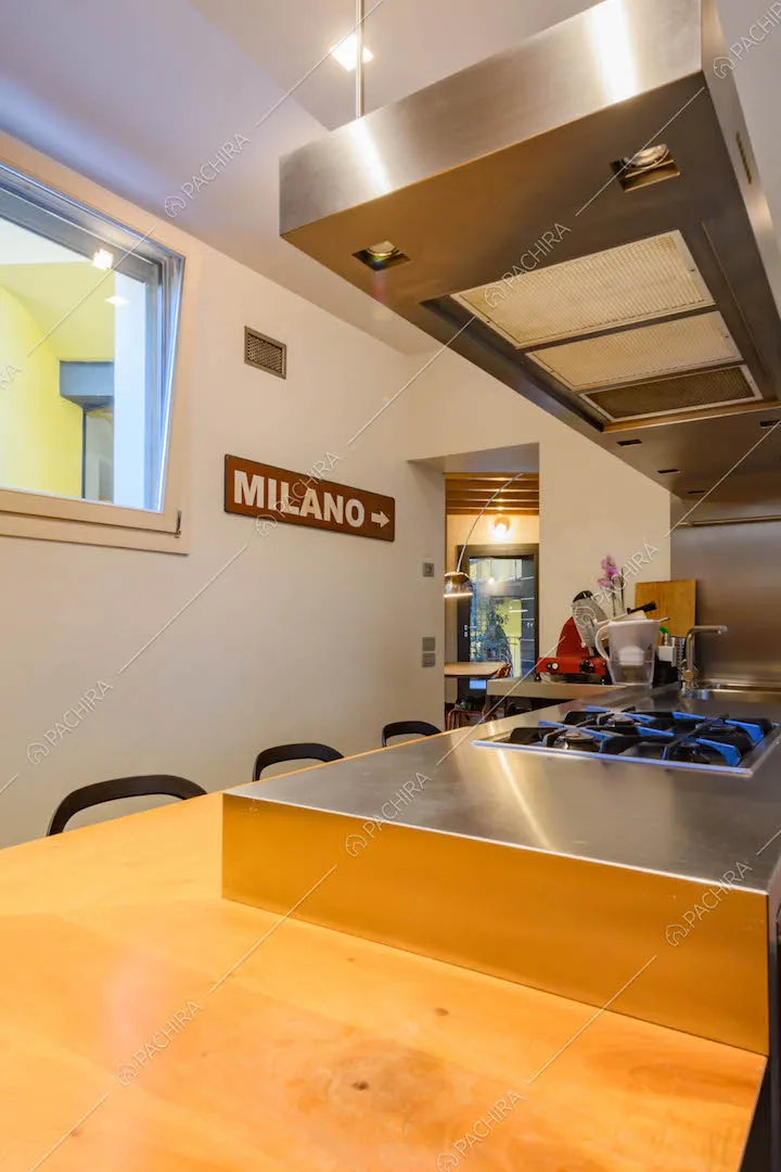 Isola della cucina con fornelli a gas e parete bianca