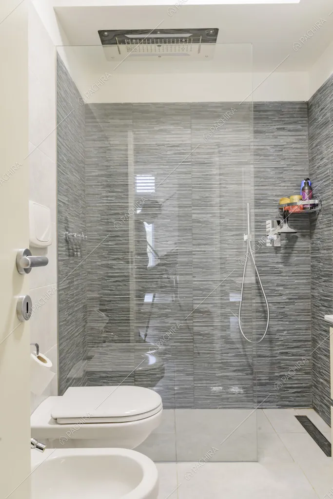 Bagno con ampio box doccia con parete in vetro