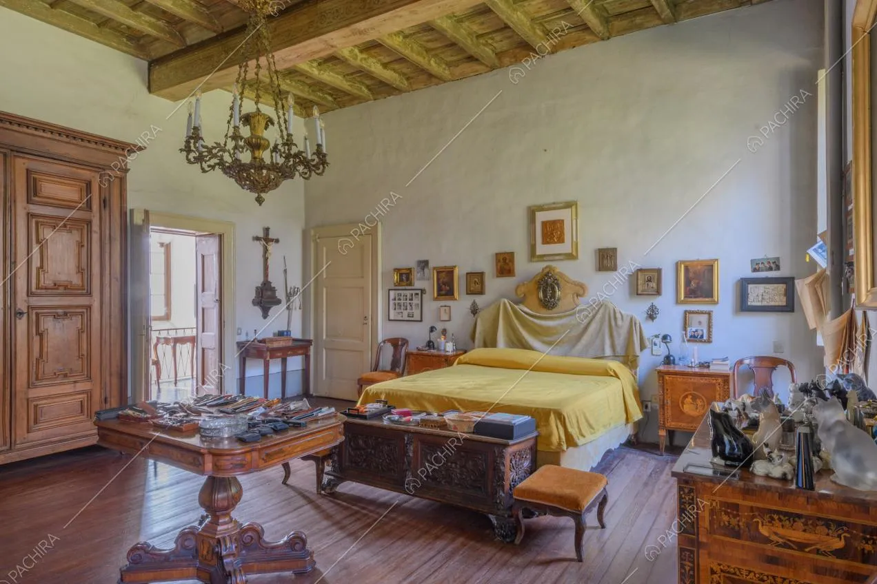 Letto matrimoniale nella camera con soffitto a cassettoni e porta-finestra