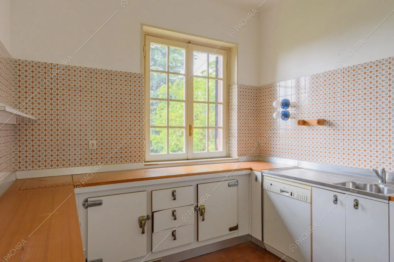 Cucina a parete con piano di lavoro in legno e piastrelle colorate