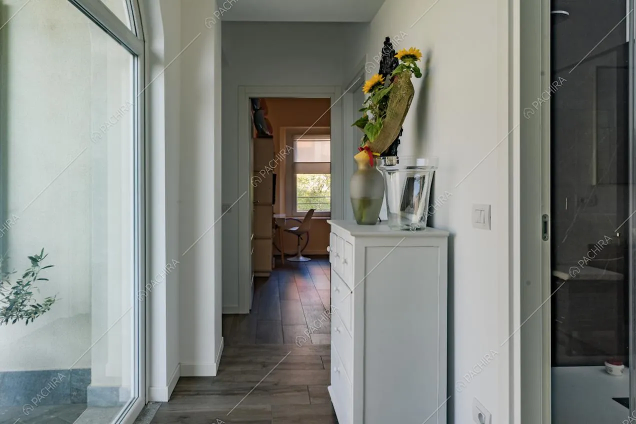 Mobiletto bianco e vasi con fiori