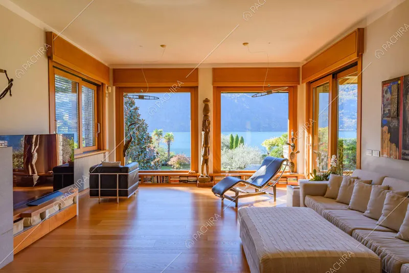 Divano con pouf e poltrona di design nella zona living con grandi vetrate