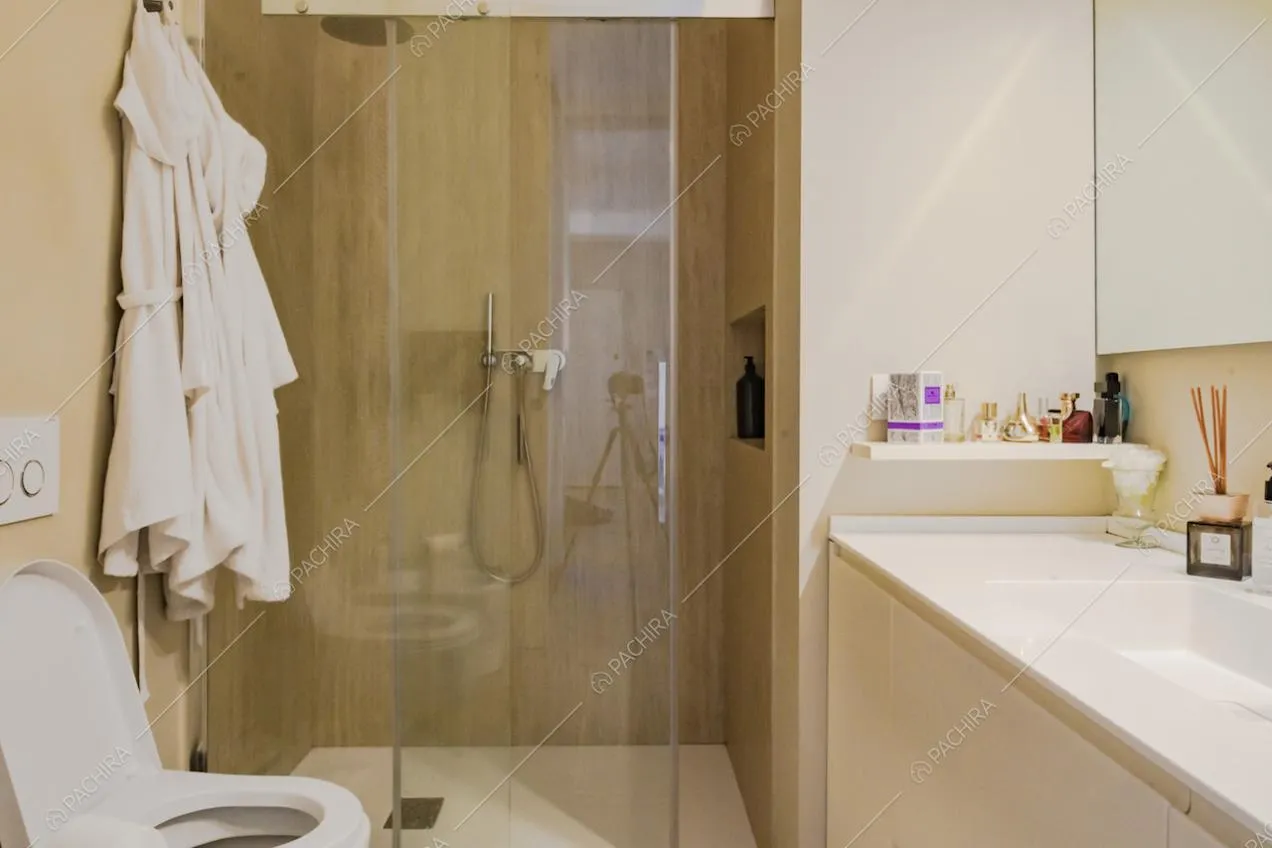 Bagno arredato con colori chiari e box doccia 