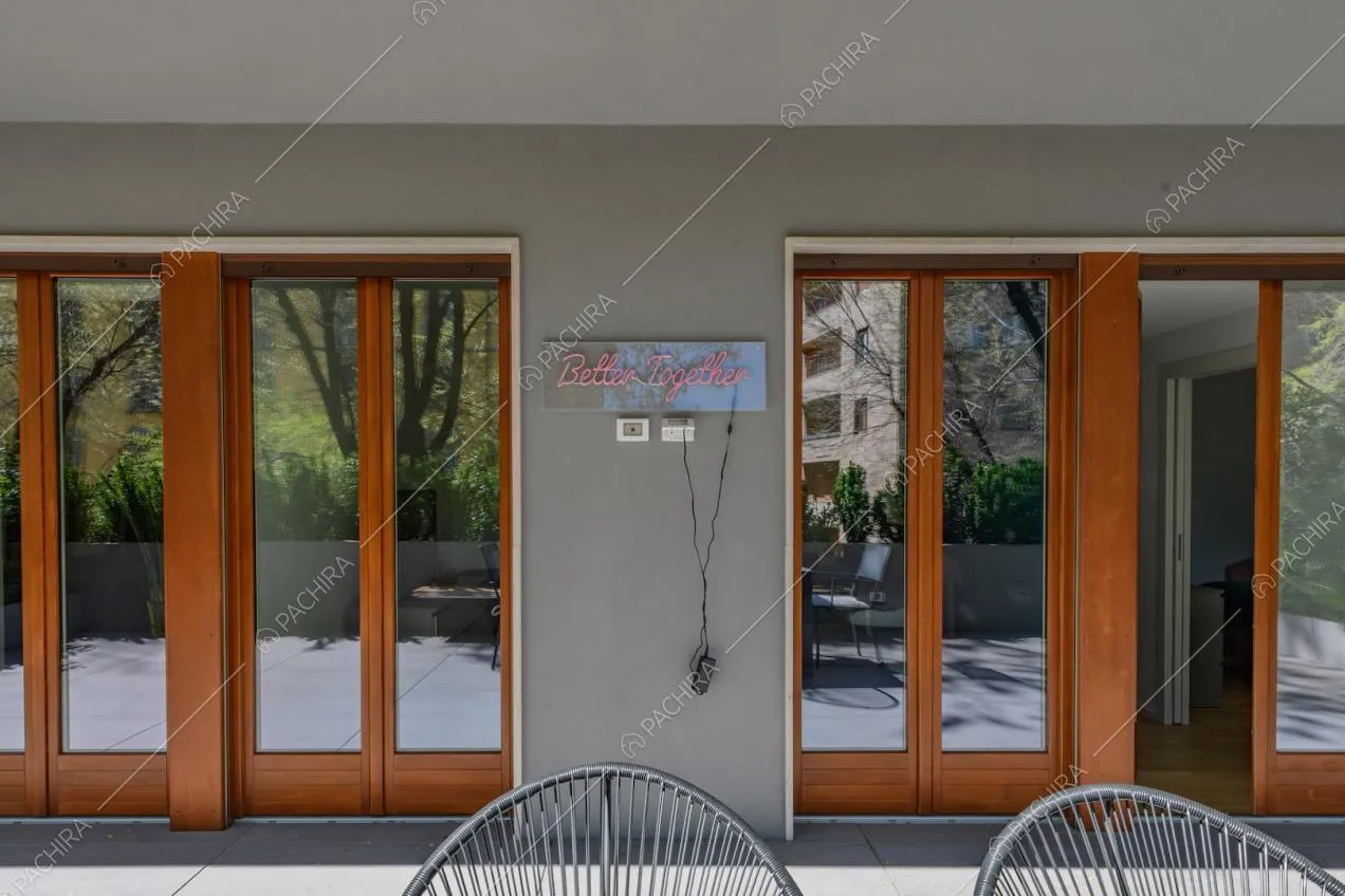 Vista sulle porte-finestre con infissi marroni in legno dalla terrazza