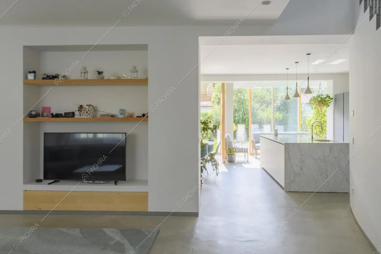 Mensole in legno sopra il televisore e vista sulla cucina