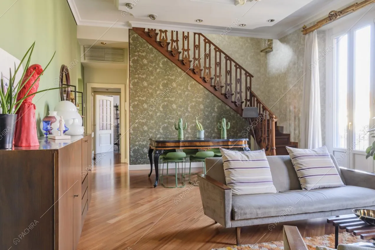 Divano grigio con cuscini e pavimento in parquet