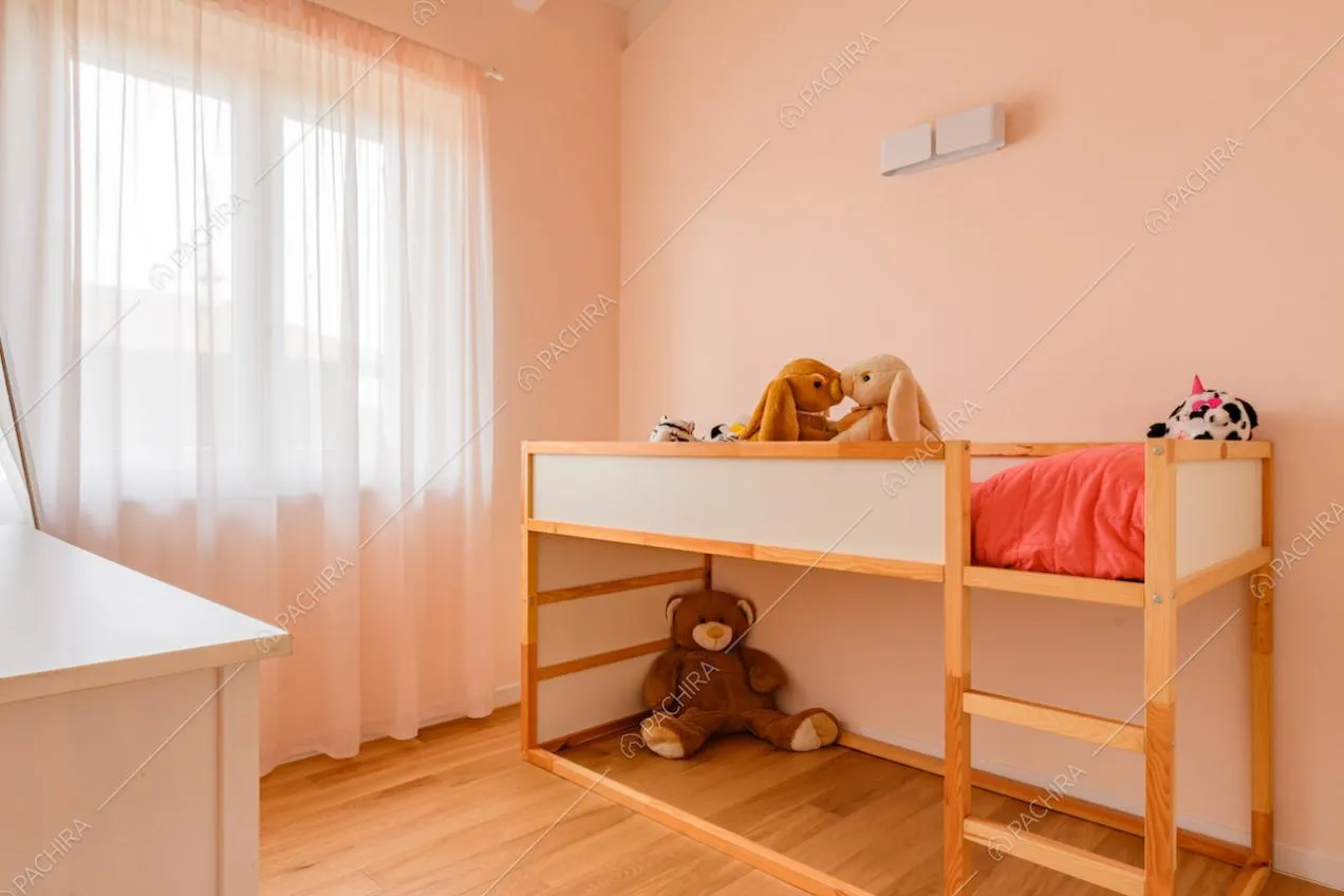 Camera da letto dei bambini con pavimento in parquet e pareti rosa