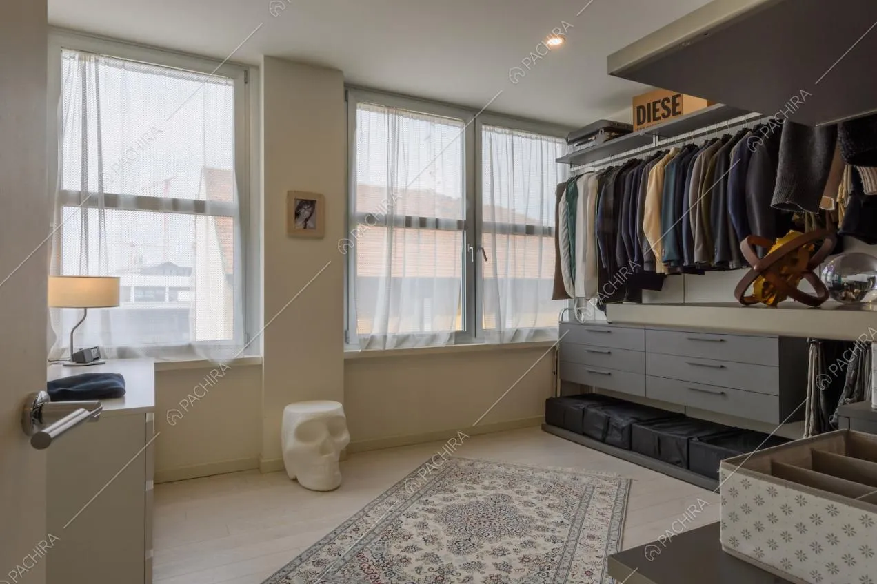 Grande cabina armadio con pavimento in parquet e finestre in stile industriale