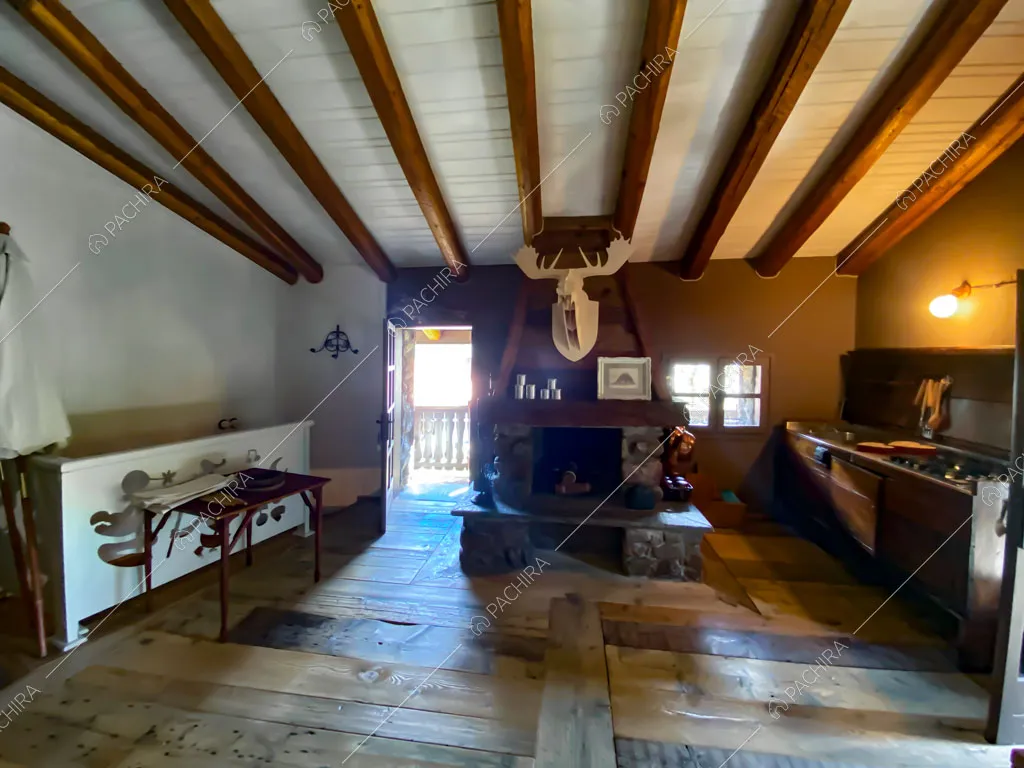 Zona living con cucina a vista dello chalet Thar, location in stile rustico ad Aosta