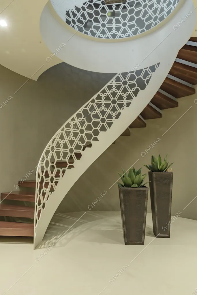 Scala a chiocciola con gradini il legno e balaustra bianca con fantasia geometrica