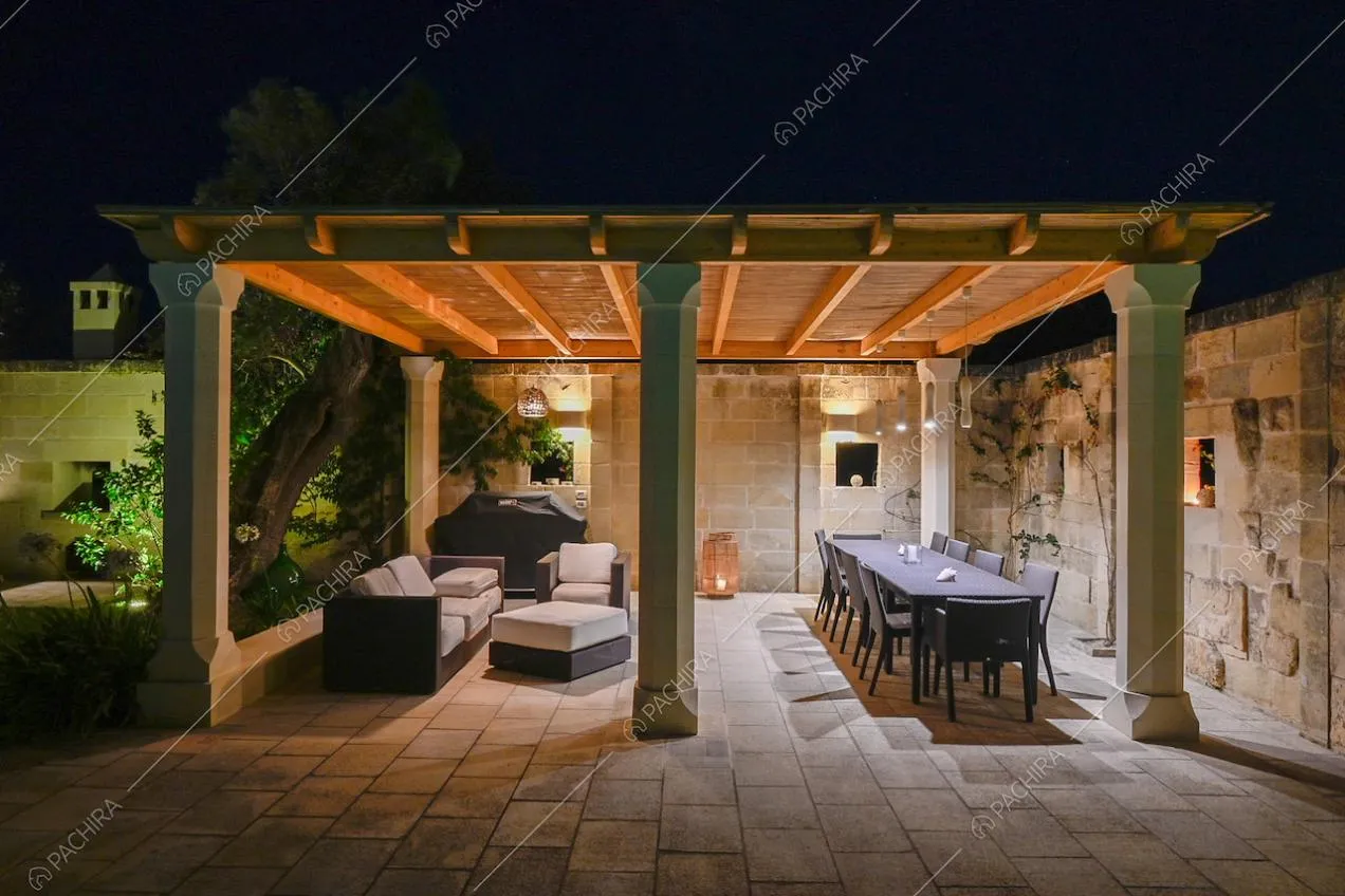 Veranda con pavimento in pietra, salotto e tavolo da pranzo da esterno