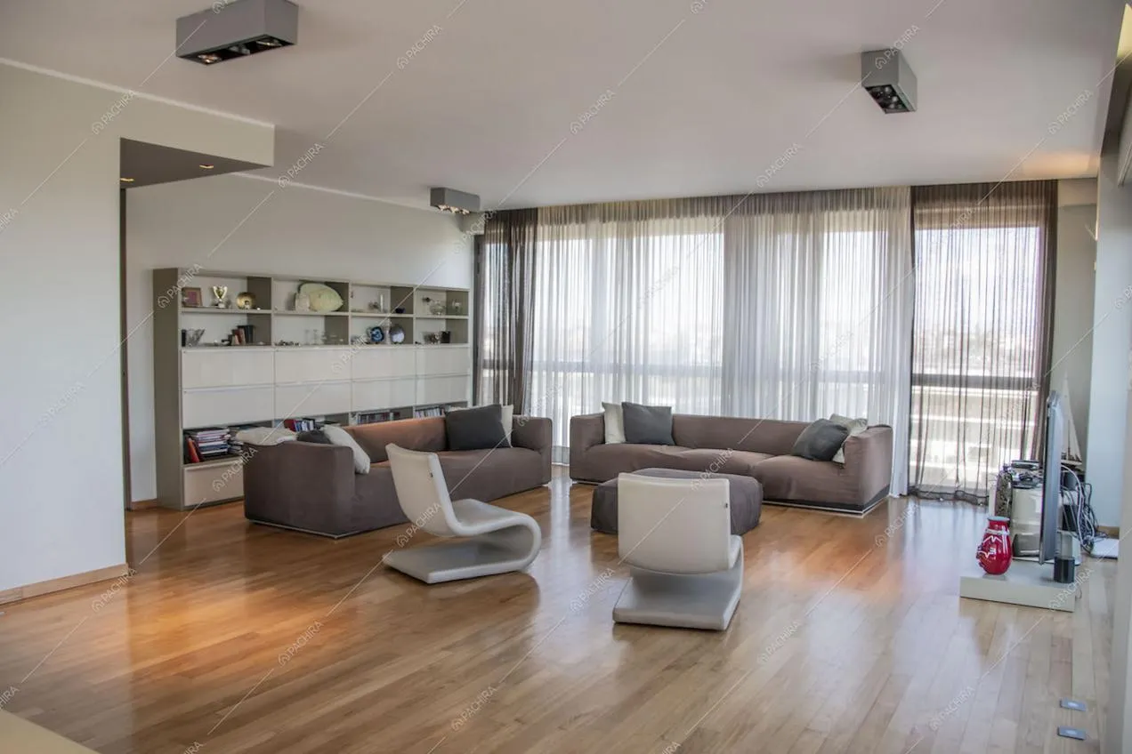 Salotto con doppio divano, pavimento in parquet e poltrone di design
