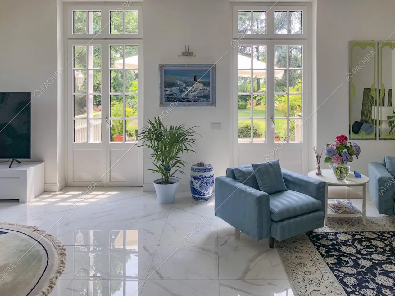Poltrona azzurra e tavolino tondo su tappeto decorato