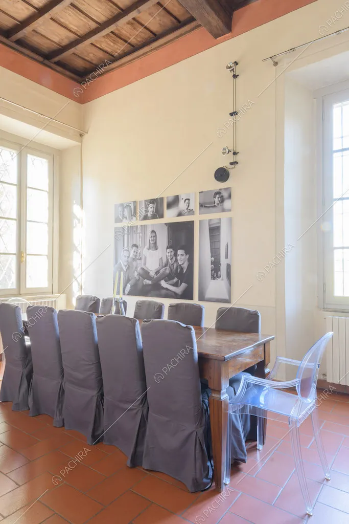 Luminosa sala da pranzo con soffitto a cassettoni, pareti bianche e pavimento in mattonelle rosse