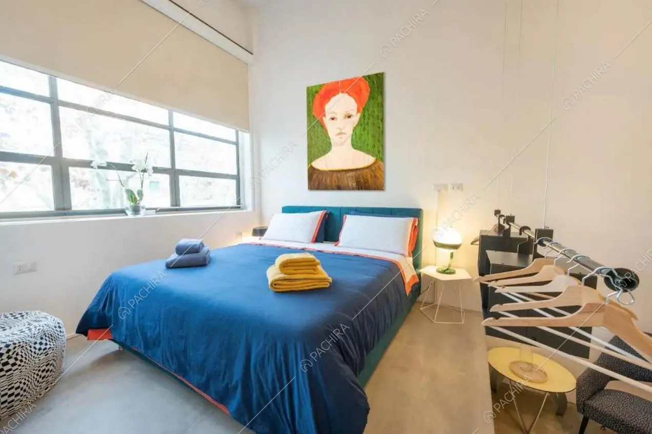 Letto matrimoniale nella luminosa camera con pareti bianche