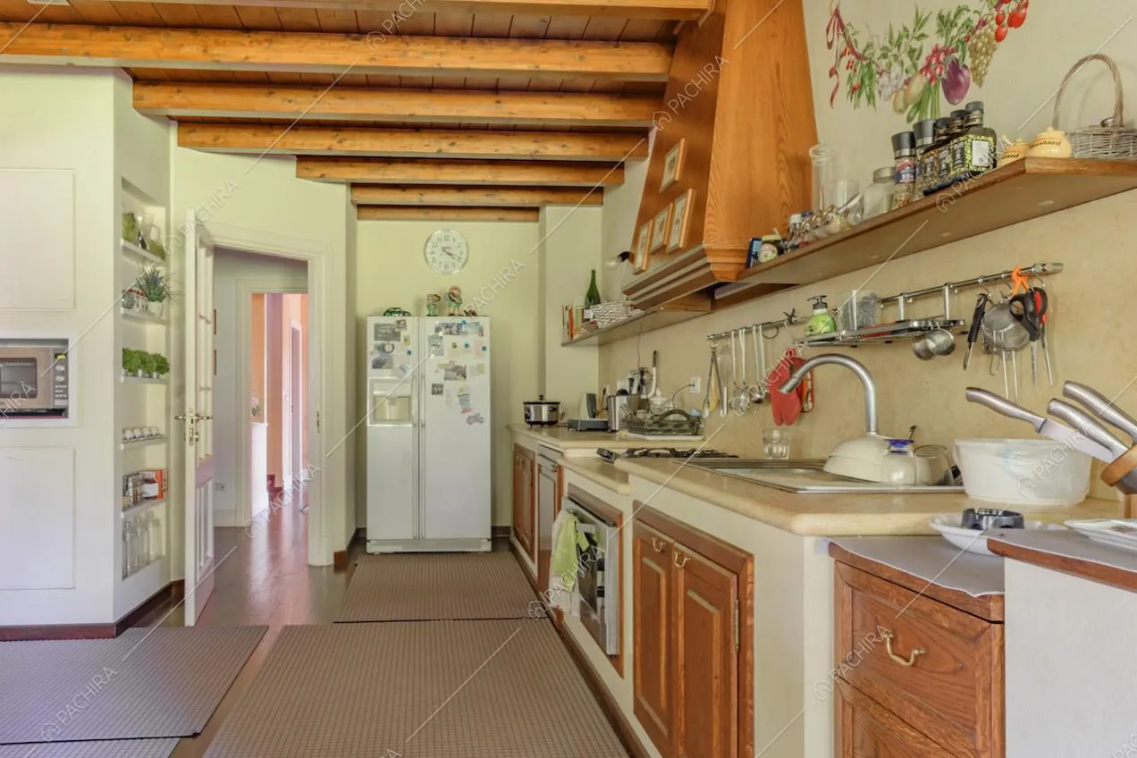 Mobili bianchi con dettagli in legno nella cucina a parete