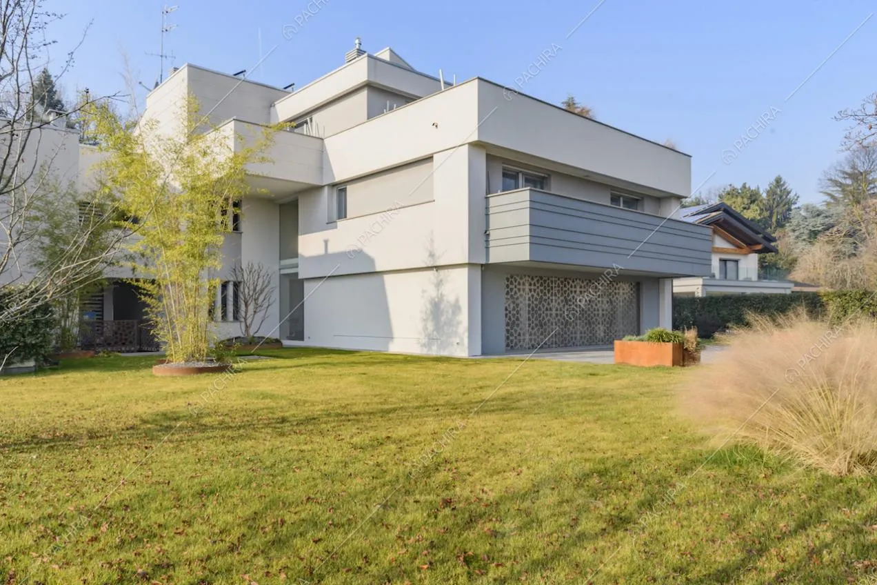Dal giardino vista sugli esterni bianchi della location con balcone e ampia terrazza