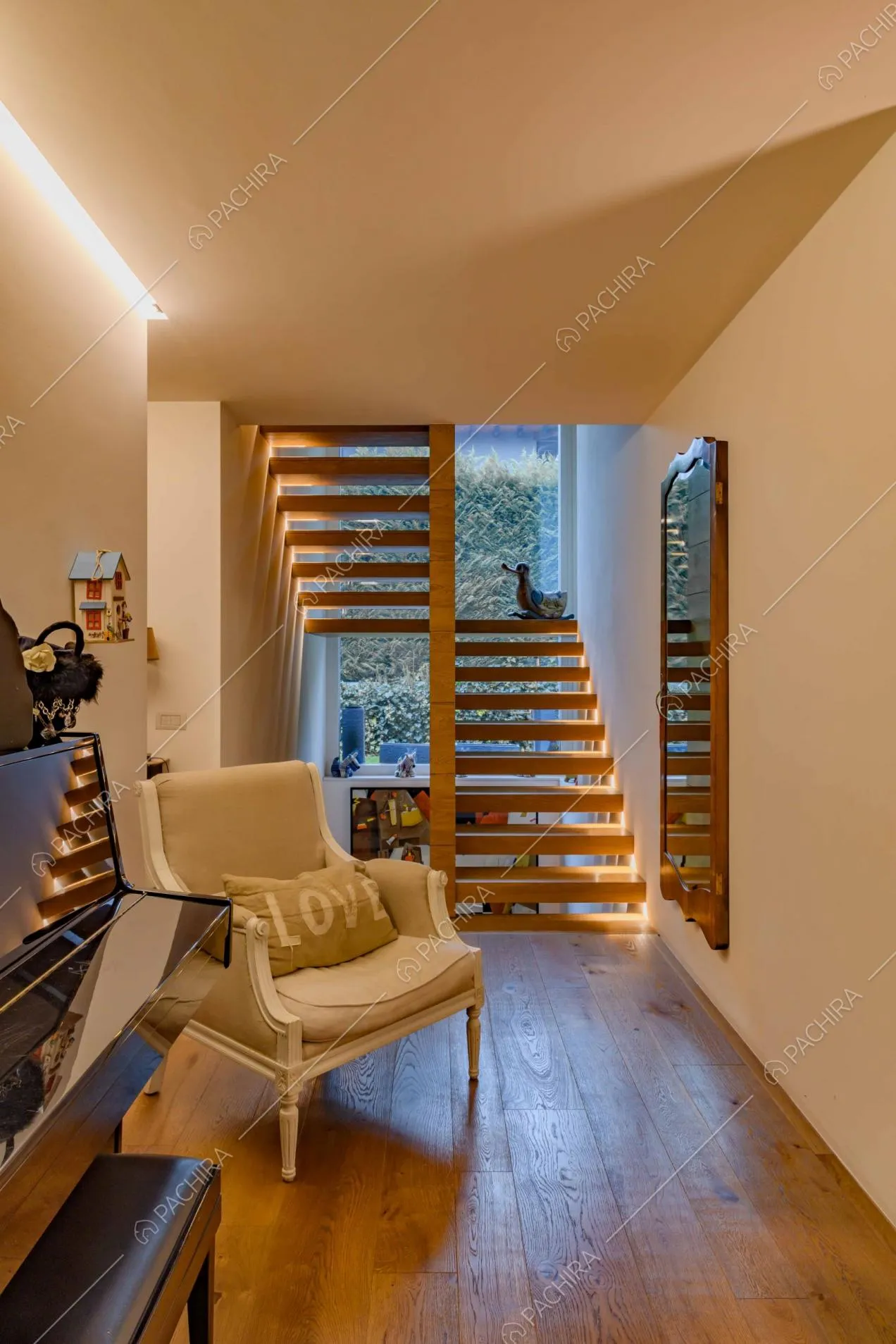 Spazio antistante le scale con pavimento in parquet e pianoforte nero a muro