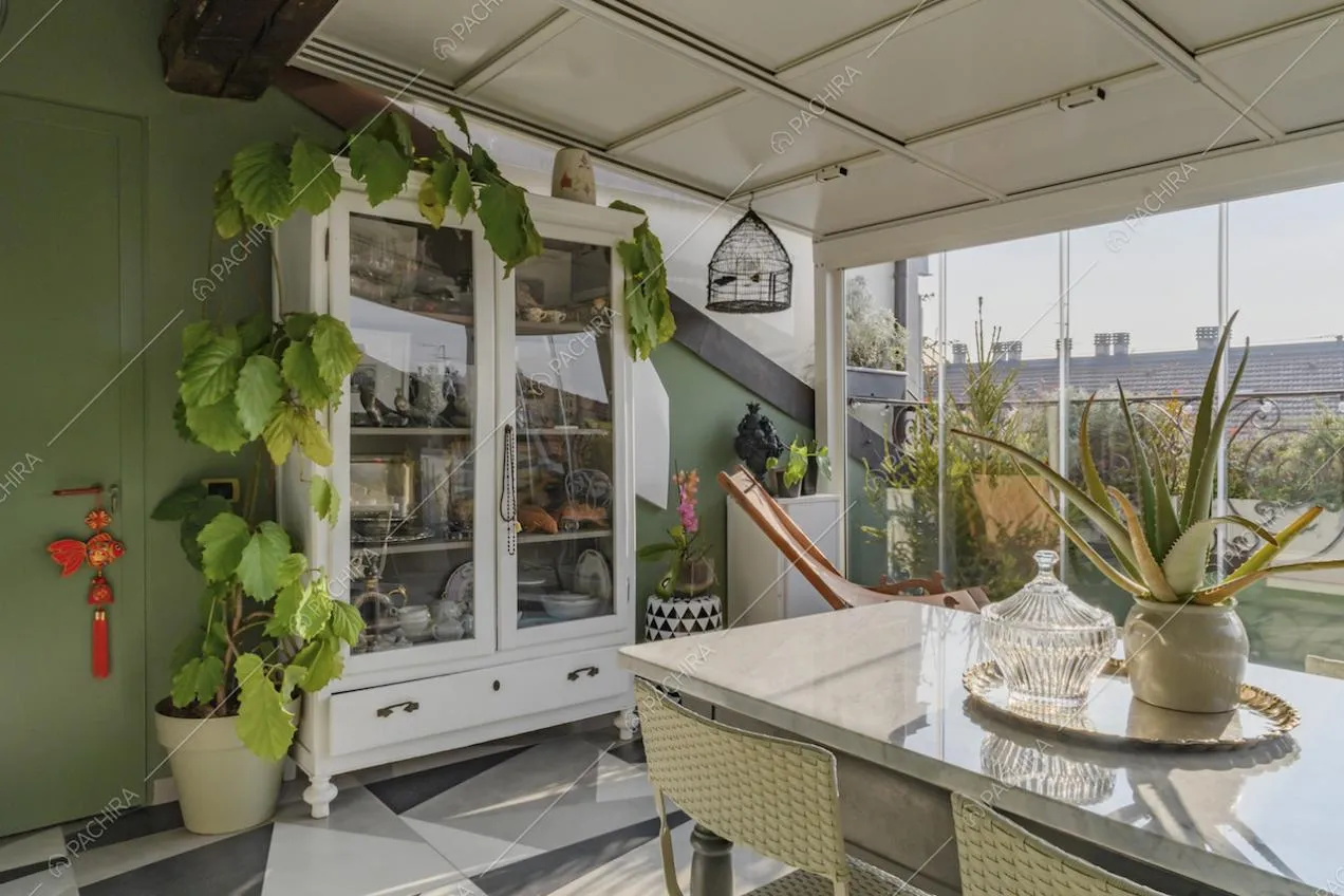 Credenza bianca con stoviglie e parete color verde