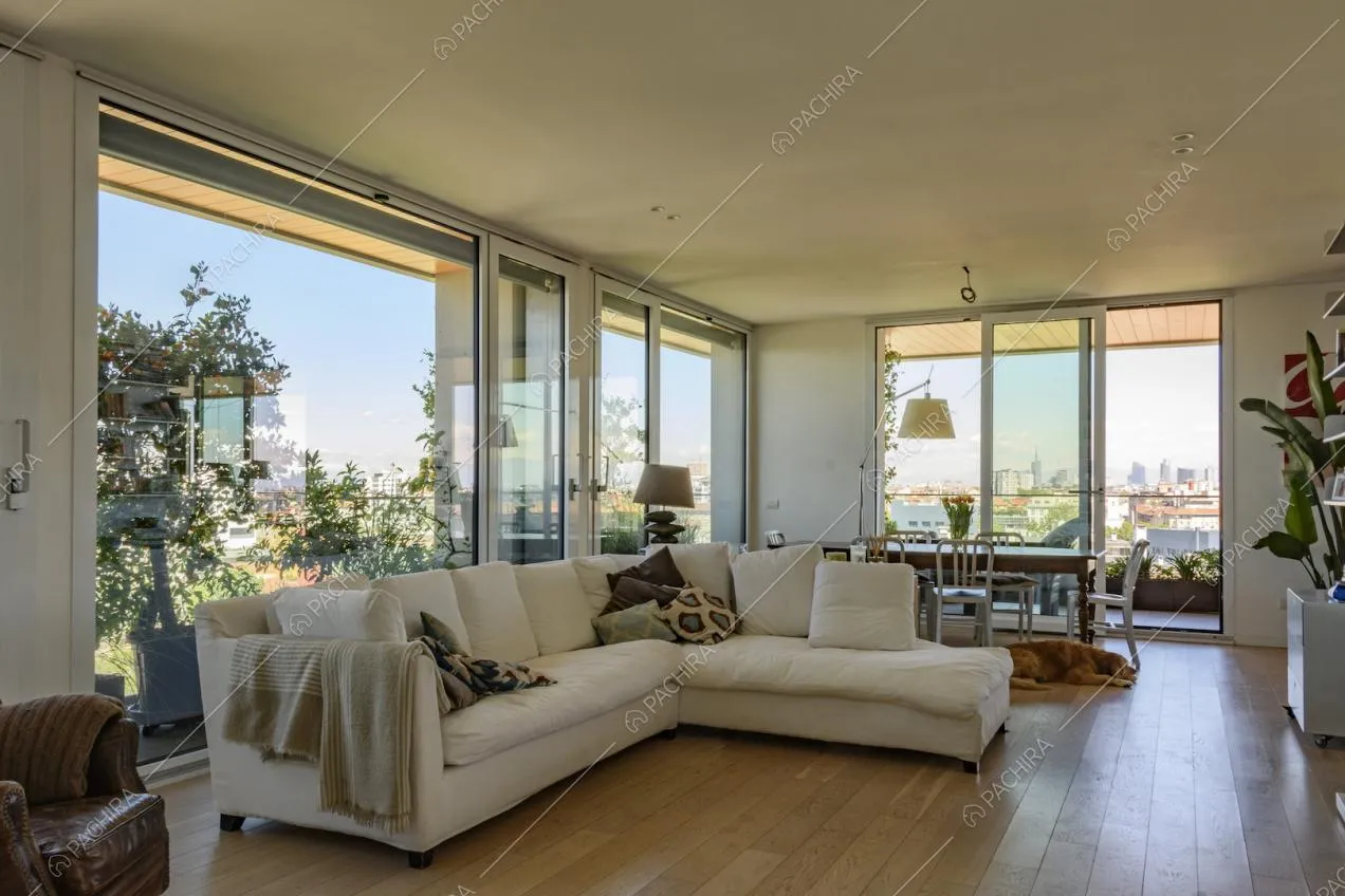 Zona giorno con grande divano bianco e parquet