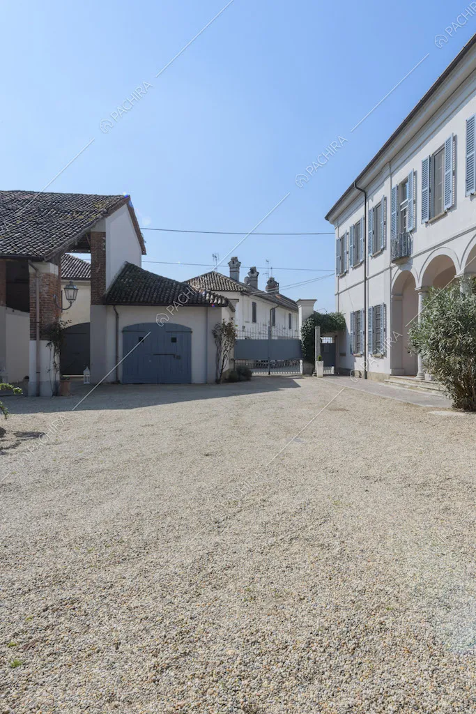 Pavimentazione in ciottoli nel cortile con cancello e vista sulla location