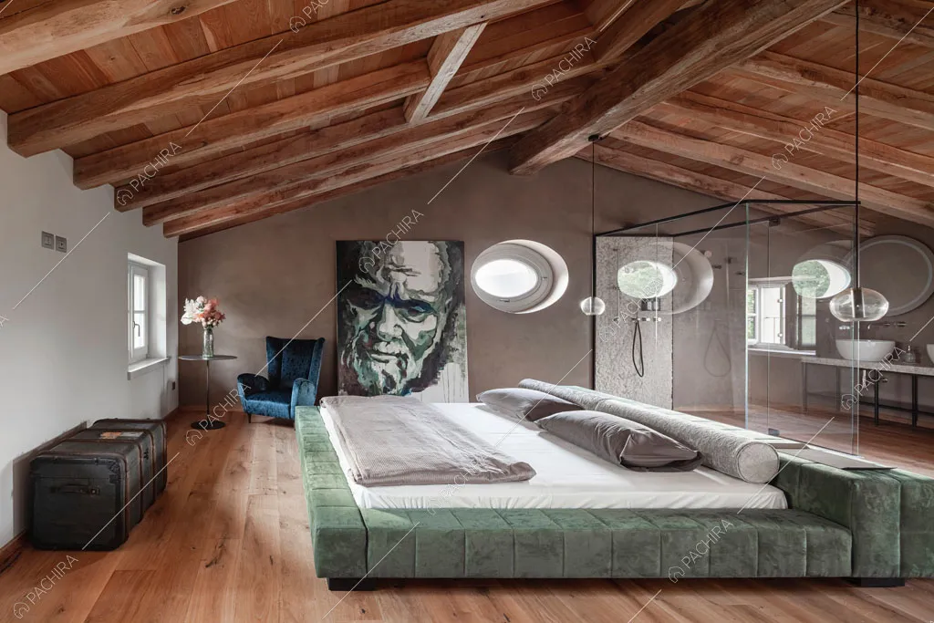 Letto matrimoniale nella camera con pavimento in parquet della villa Ghibli, location in stile contemporaneo a Verona