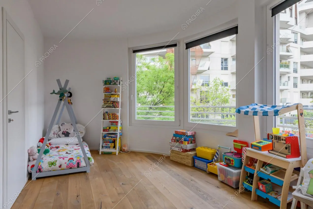 Pavimento in parquet e pareti bianche nella luminosa camera dei bambini