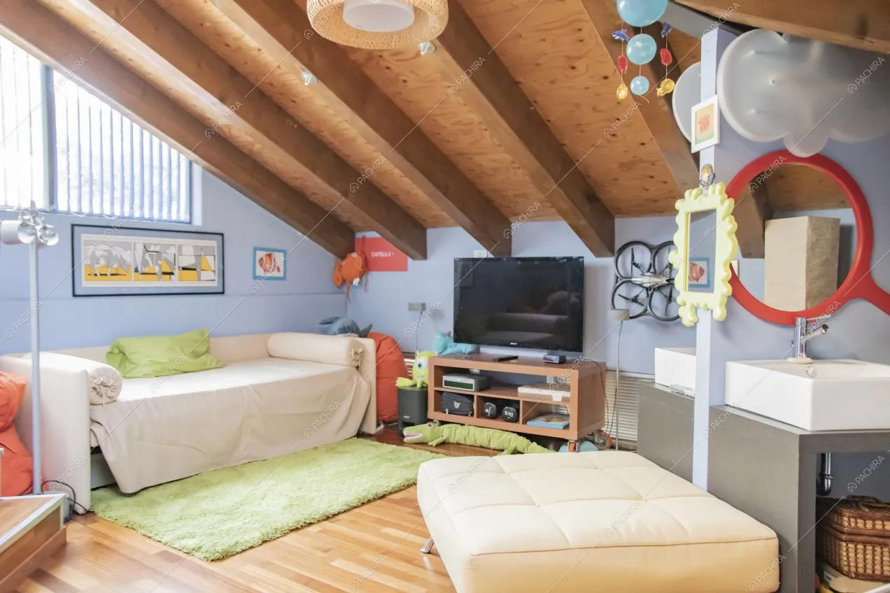 Camera con pavimento in parquet, pareti azzurre, lavandino e soffitto con travi in legno a vista