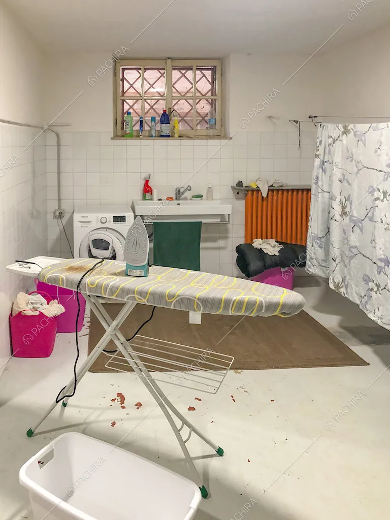 Locale lavanderia con lavatrice e ferro da stiro
