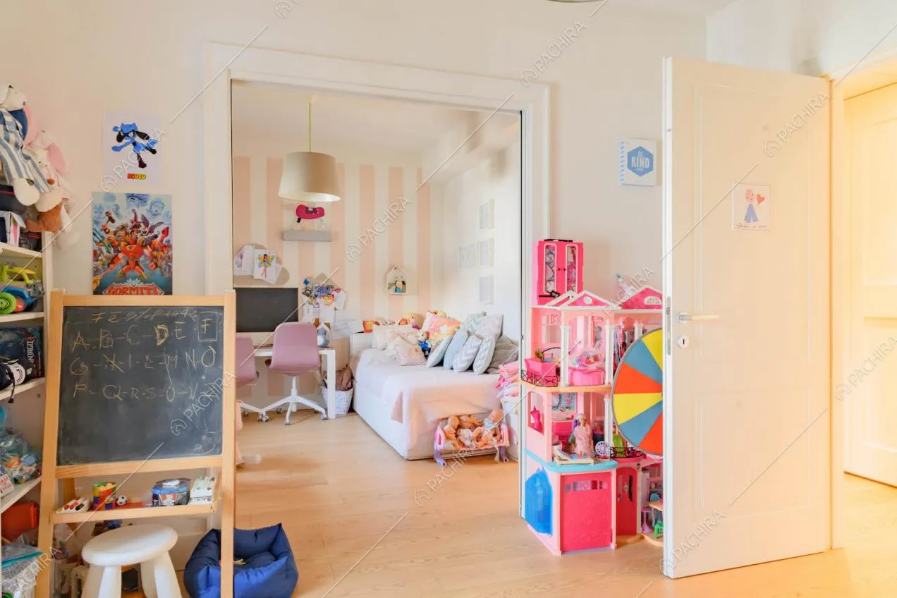 Pavimento in parquet nelle camere da letto dei bambini e parete a strisce bianche e rose