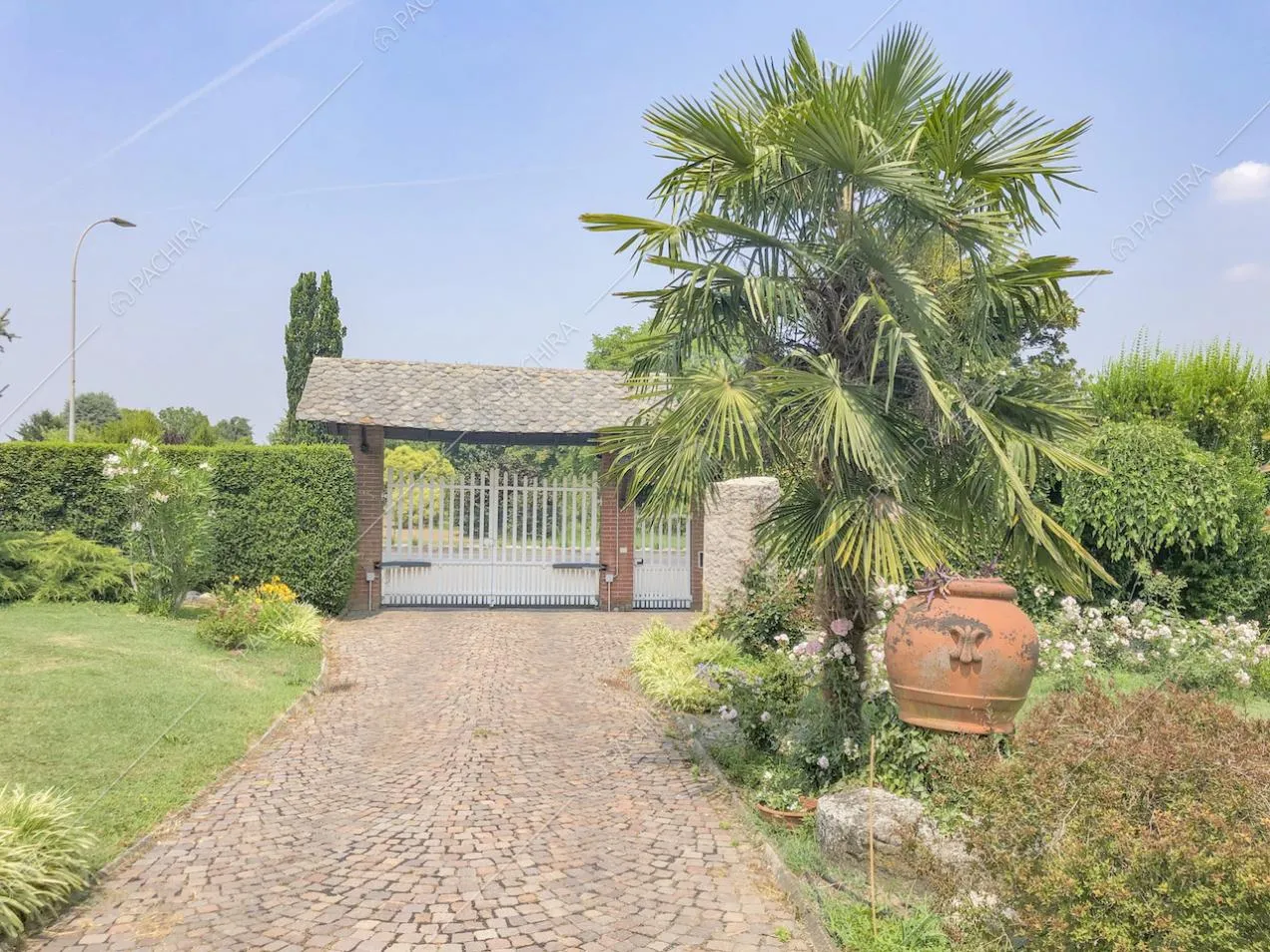 Cancello d'entrata con tettoia in mattoni e piante