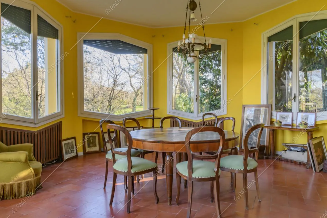Luminosa sala da pranzo dalle pareti gialle e dall'arredamento classico
