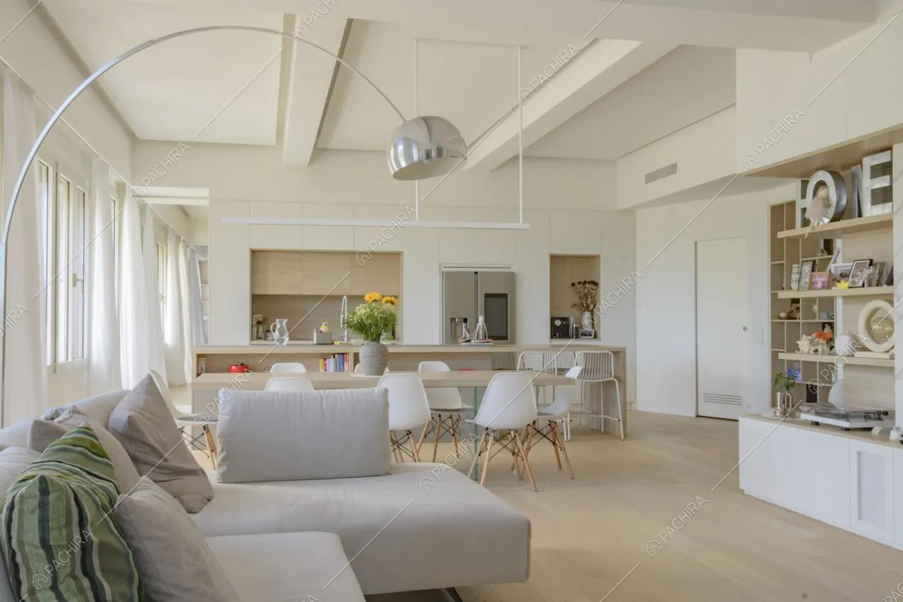 Zona giorno dai colori tenui con lampada ad arco di design