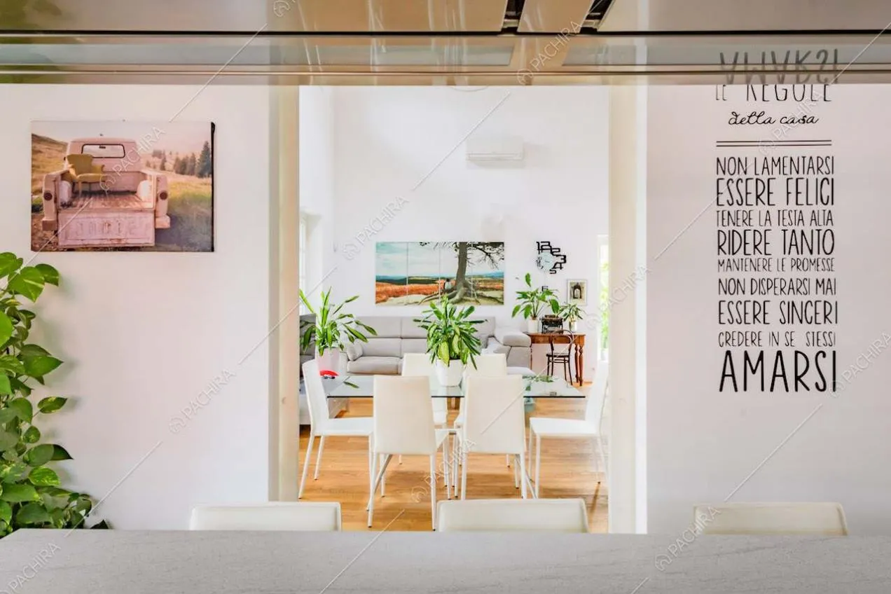 Dalla cucina vista sulla zona living con tavolo da pranzo e pavimento in parquet