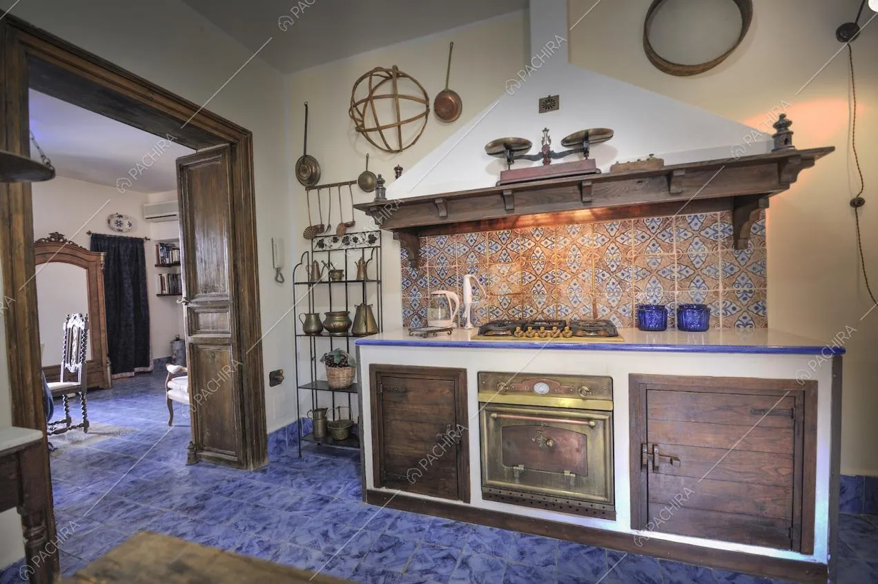 Cucina antica con utensili d'epoca e grande porta in legno