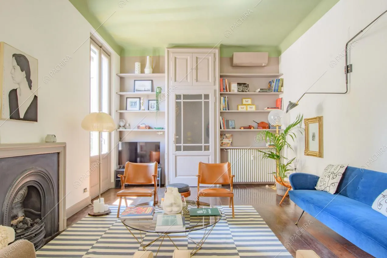 Camino nero nella luminosa zona living con soffitto verde e pavimento in parquet
